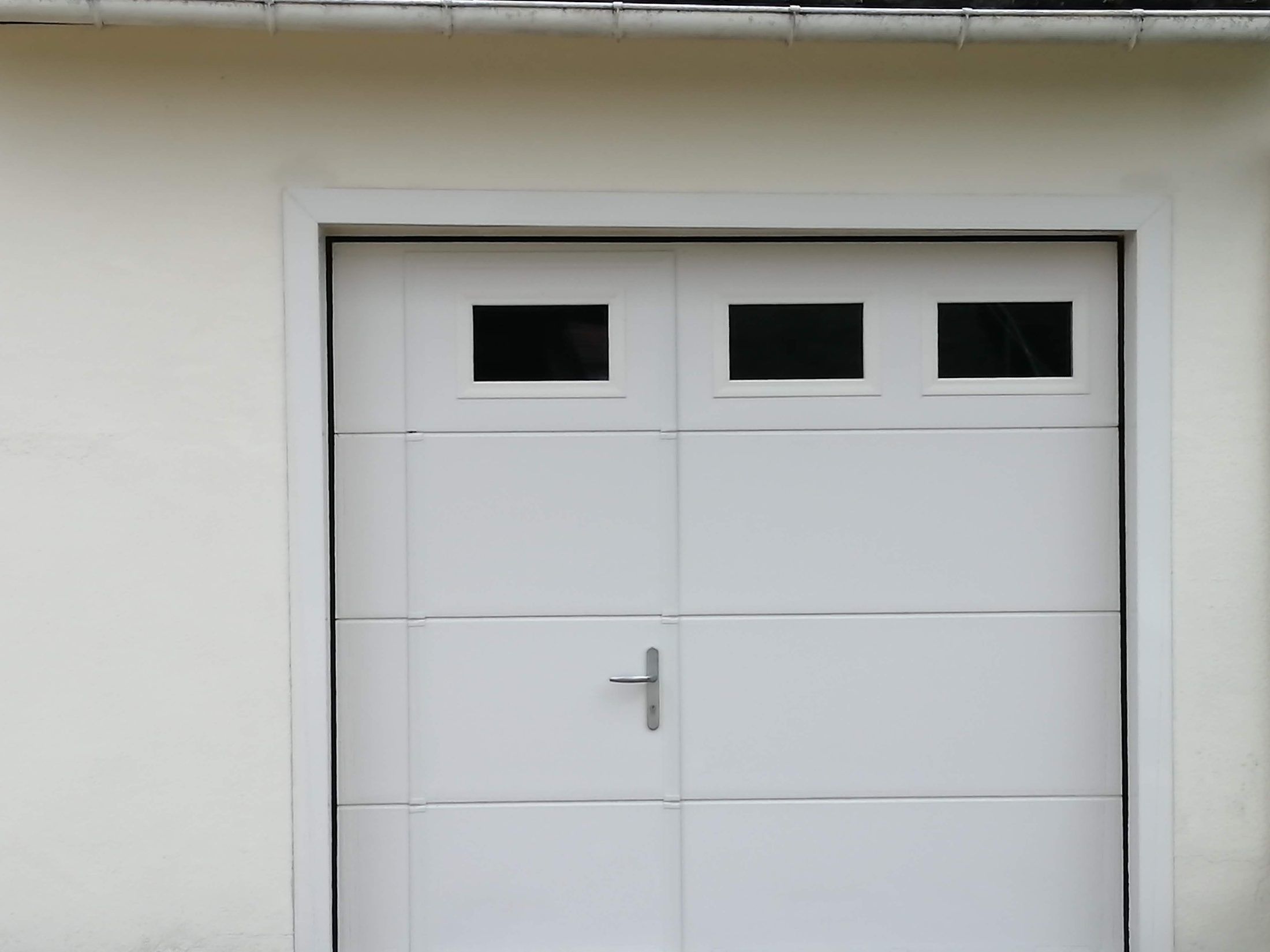 Porte de garage sectionnelle avec portillon et hublots — Pays jonzacais